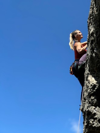 Emma Alwyn, climbing action shot.