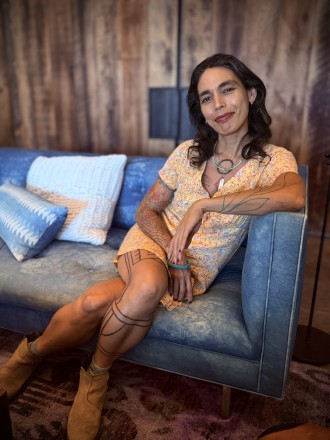 Somatic sexologist Ixchel Xochitlzihuatl sitting portrait shot, smiling