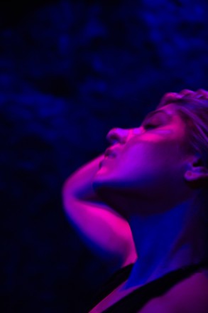 Emma Colangelo, sex educator and sexologist, artistic side face shot, pink and blue atmospheric hues